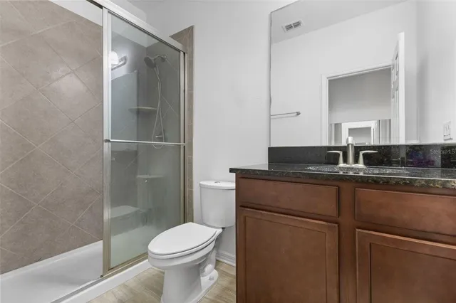 a bathroom with a granite countertop sink toilet and shower
