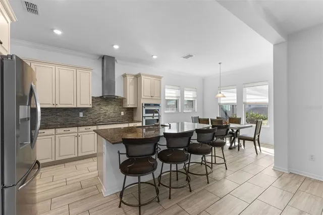 a kitchen with a dining table chairs and white cabinets