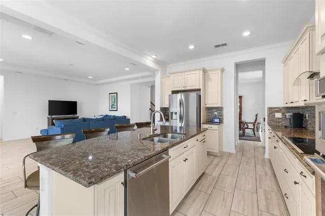a large kitchen with sink a counter top space and stainless steel appliances