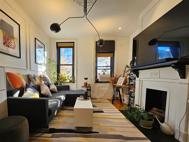 a living room with furniture a flat screen tv and a fireplace