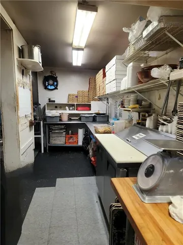 a kitchen with stainless steel appliances a stove a sink dishwasher and a refrigerator with wooden floor