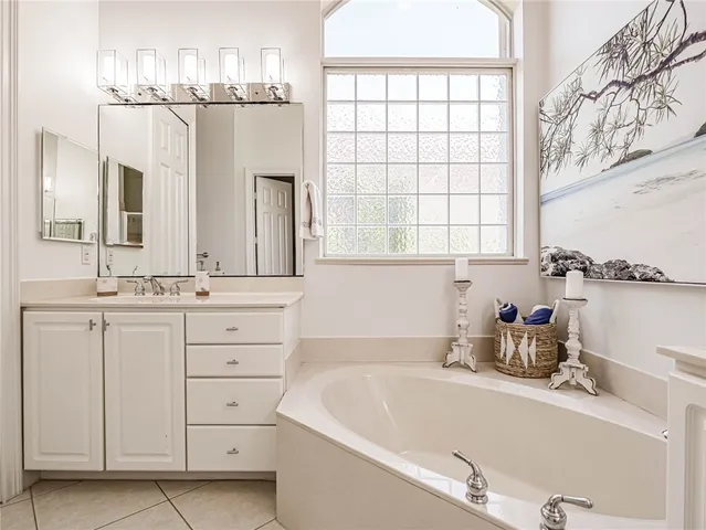 a bathroom with a tub sink and mirror