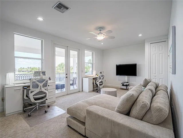 a living room with furniture a flat screen tv and a large window