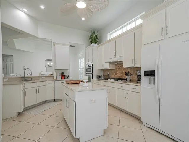 a kitchen with cabinets appliances a sink and a counter top space