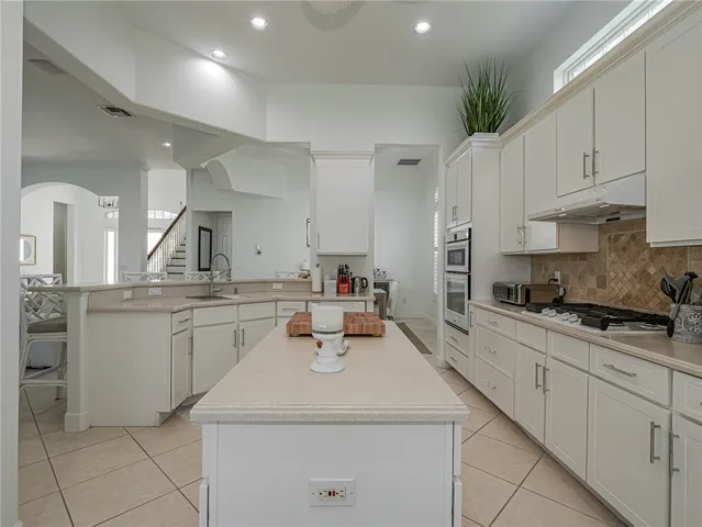 a kitchen with a sink white cabinets and stove