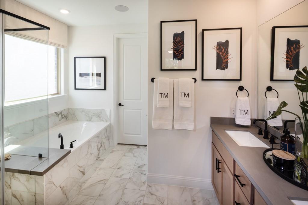 550 Wisteria Street Oak Point, TX 75068 - Photo 15 of 27 a bathroom with double vanity sink a mirror a bathtub and next to a window