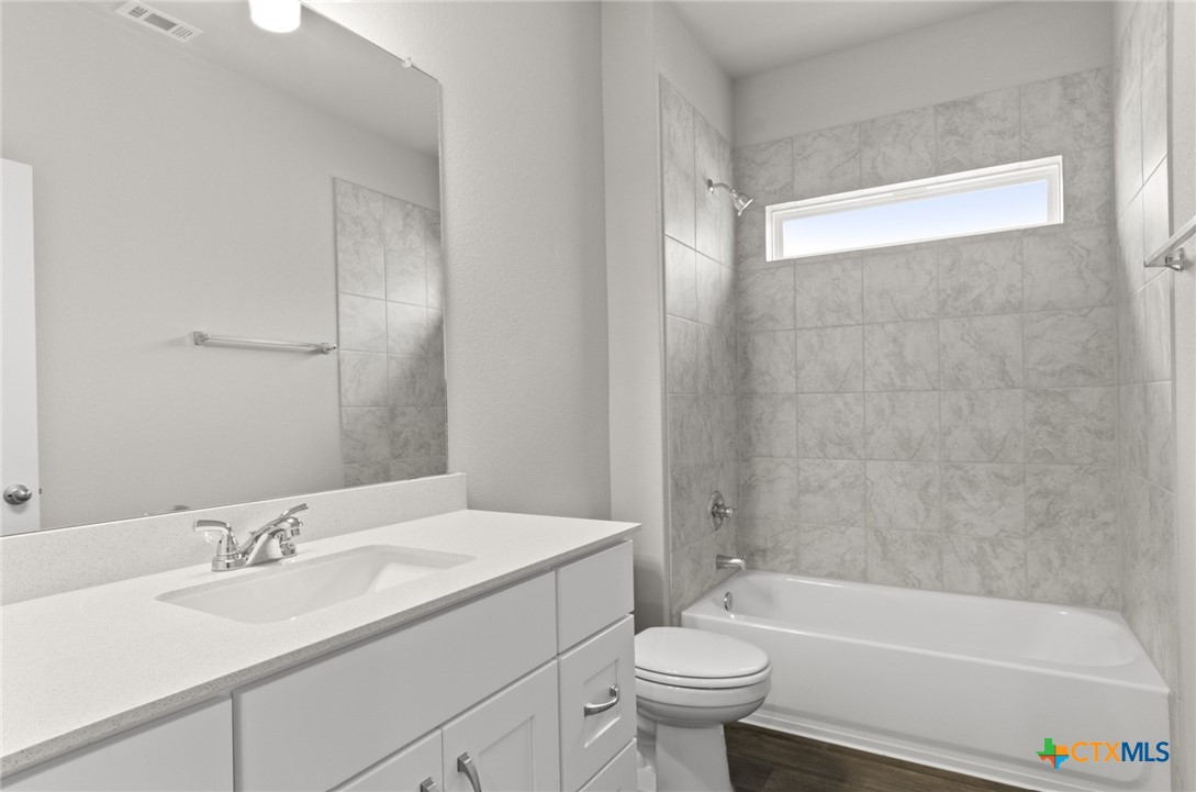 2431 Winding Creek Road Kyle, TX 78640 - Photo 15 of 29 a bathroom with a sink mirror toilet and bathtub