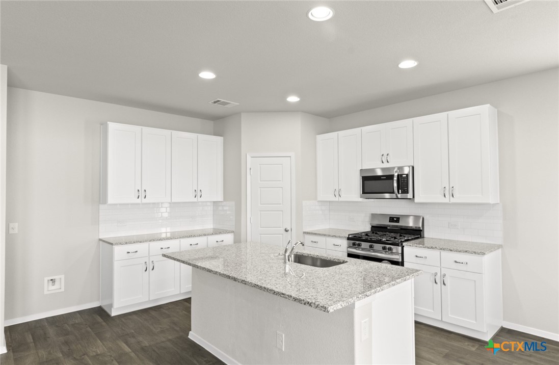 2431 Winding Creek Road Kyle, TX 78640 - Photo 2 of 29 a kitchen with stainless steel appliances granite countertop a sink a stove and a refrigerator