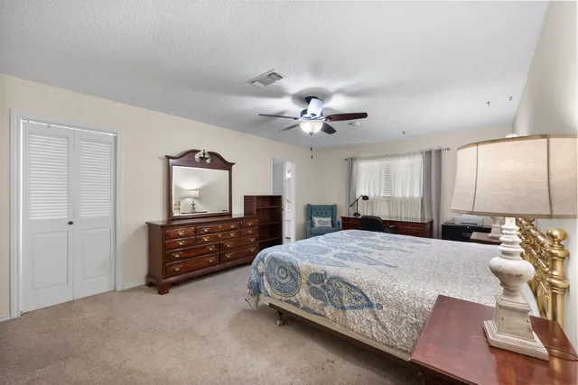 a bedroom with a large bed and a chandelier