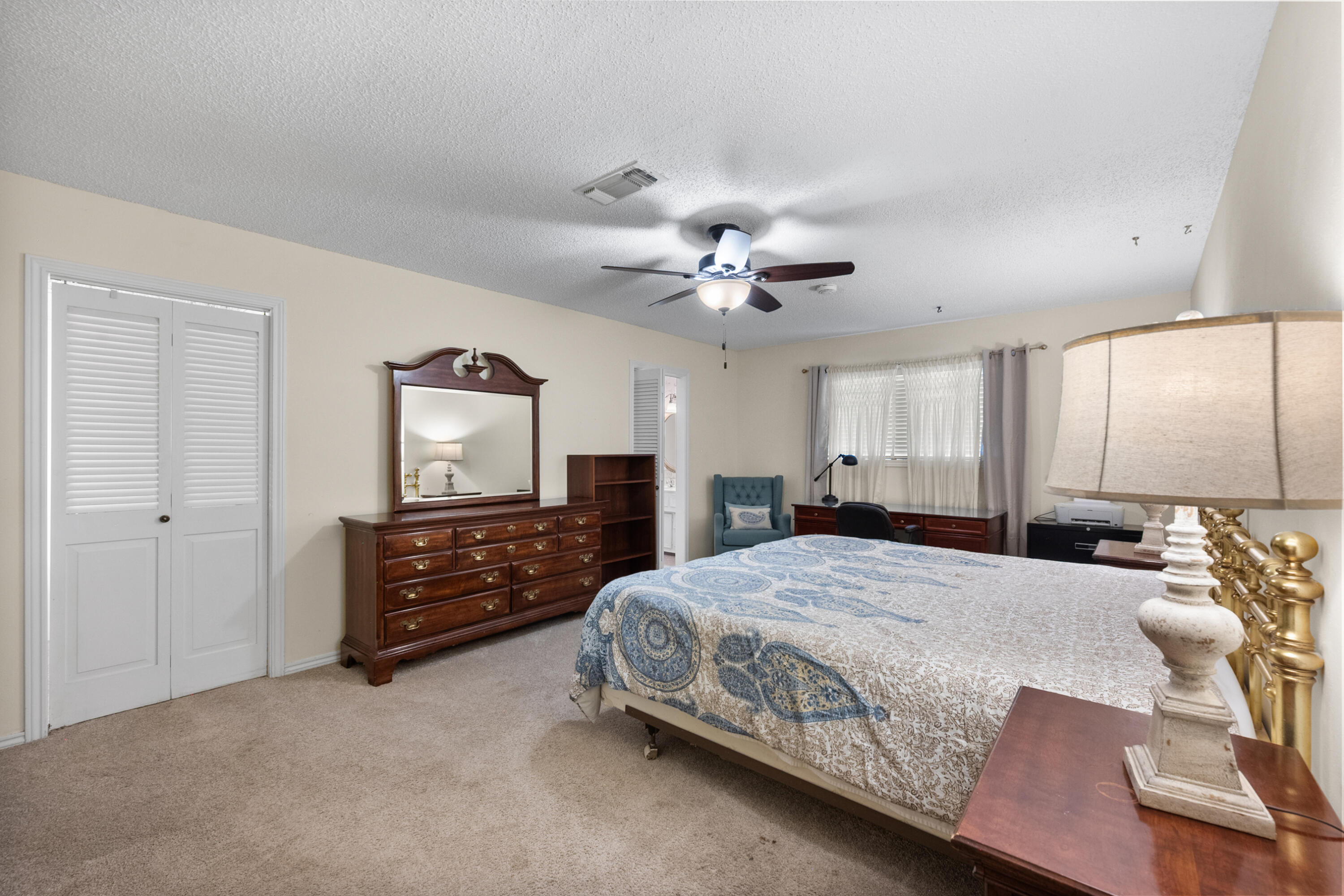 3801 66th Street Lubbock, TX 79413 - Photo 17 of 36 a bedroom with a large bed and a chandelier