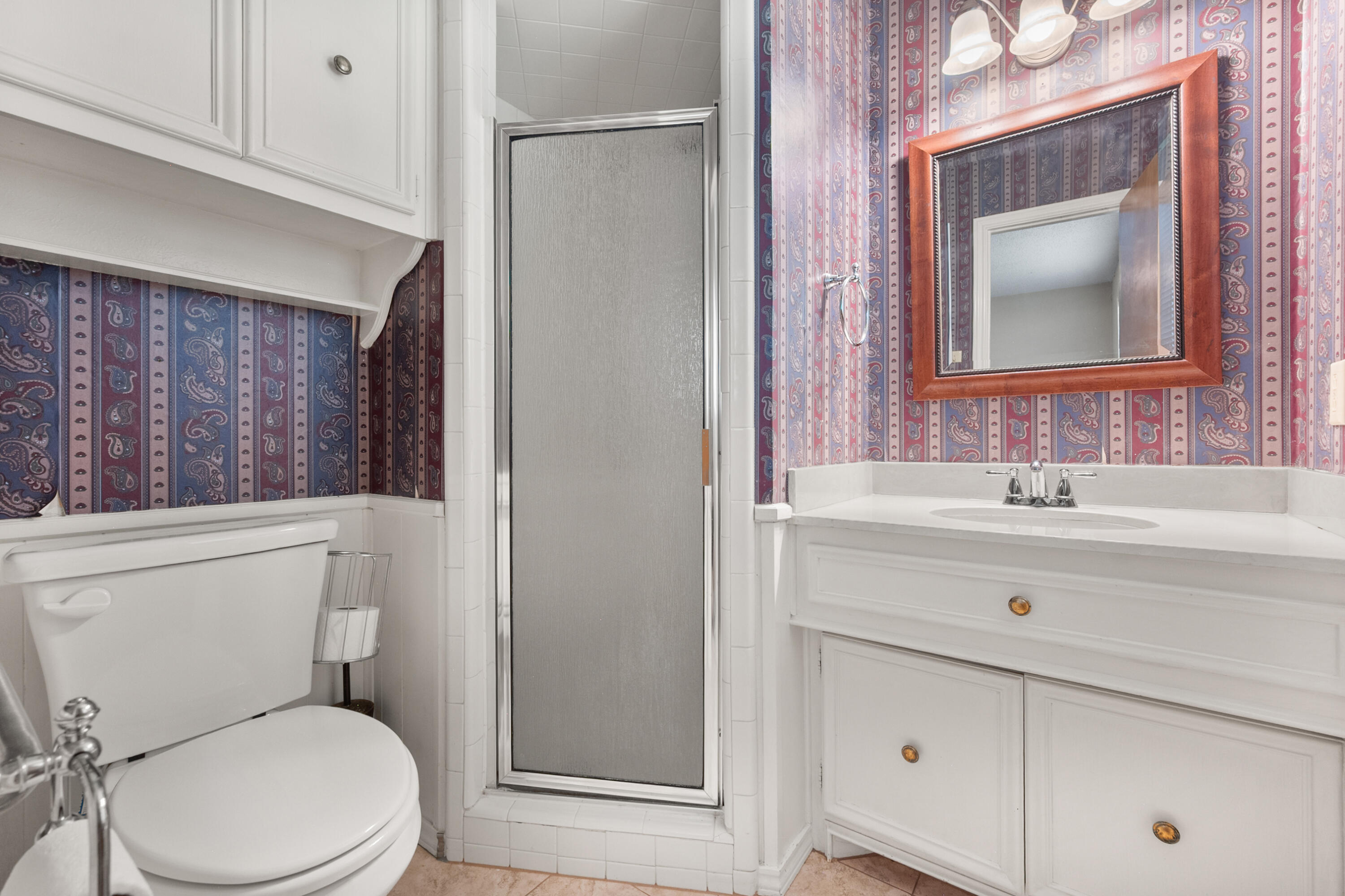 3801 66th Street Lubbock, TX 79413 - Photo 27 of 36 a bathroom with a toilet a sink a mirror and a shower