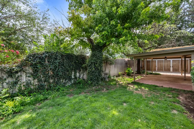 a view of a backyard with table and chairs and wooden fence