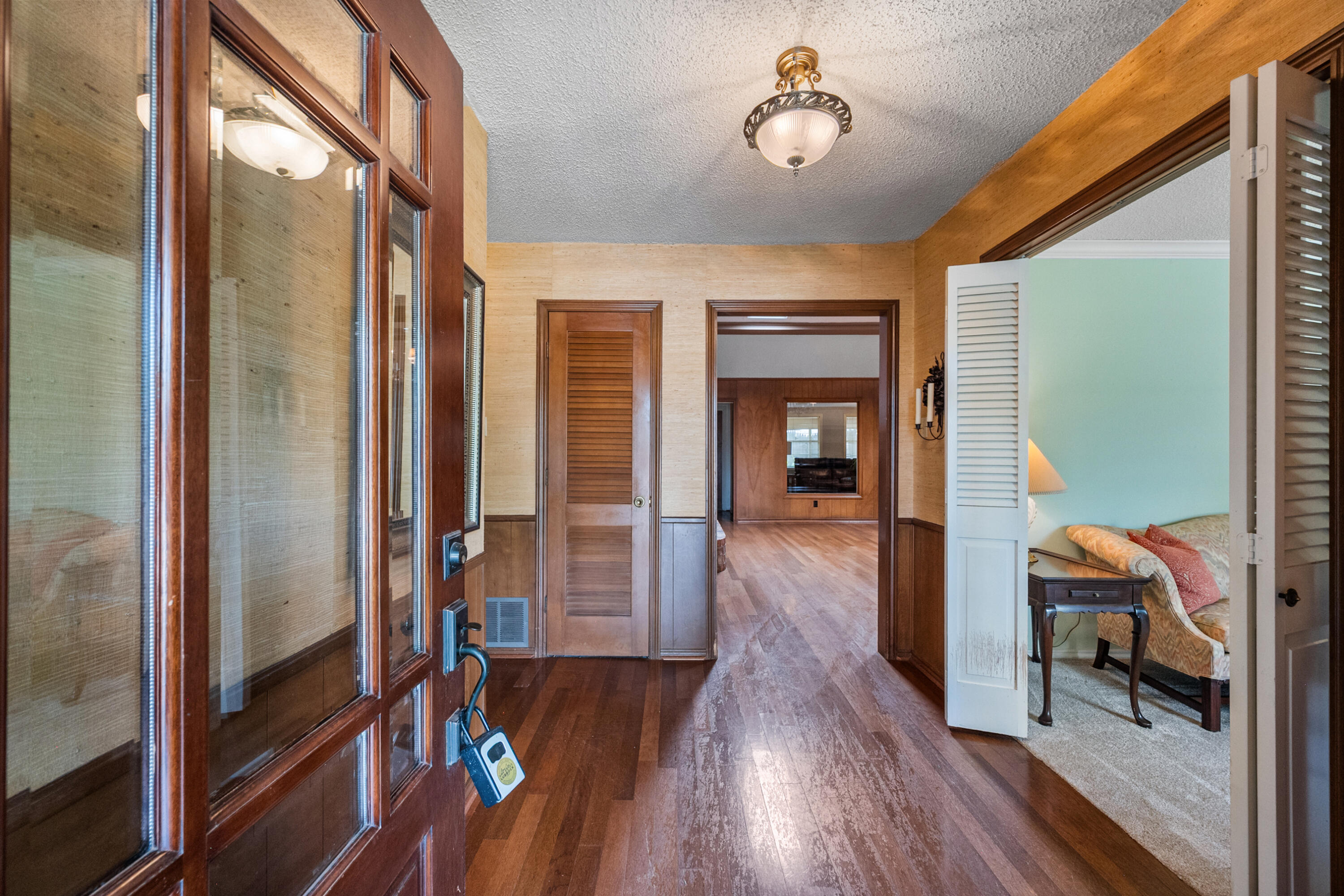 3801 66th Street Lubbock, TX 79413 - Photo 3 of 36 a view of a hallway with wooden floor and livingroom with furniture