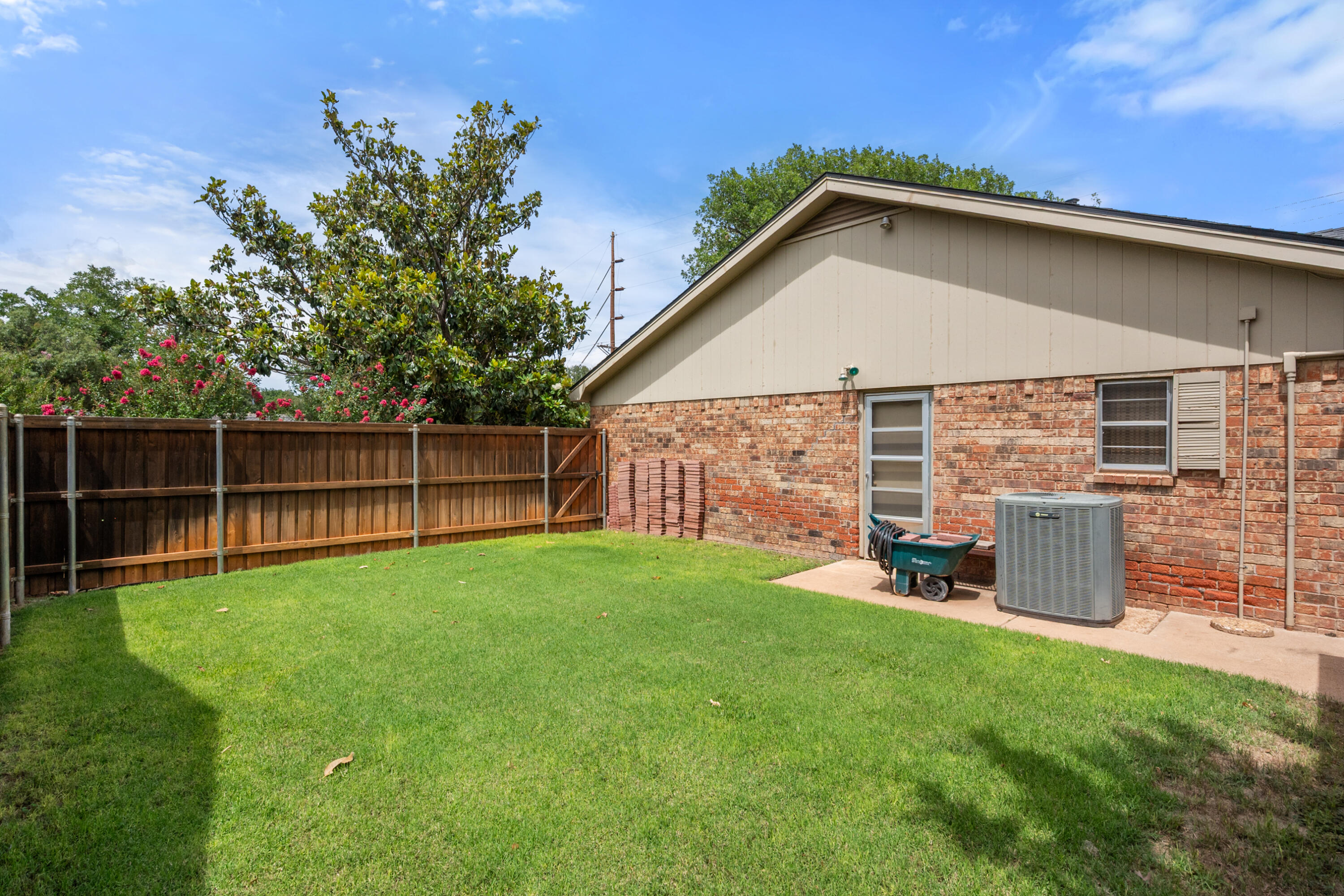 3801 66th Street Lubbock, TX 79413 - Photo 31 of 36 a view of a backyard with plants and wooden fence