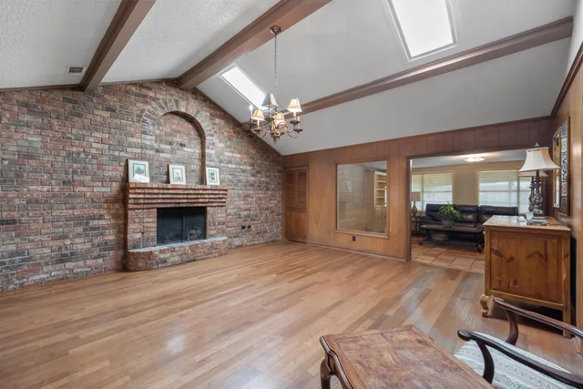 a living room with furniture a fireplace and a chandelier