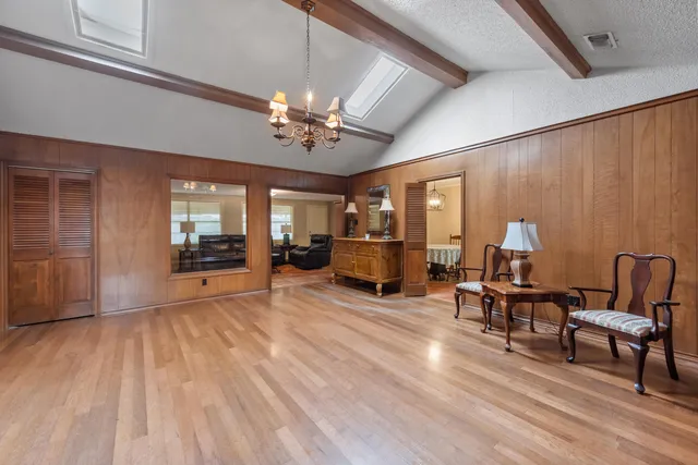 a view of a room with furniture a chandelier and wooden floor