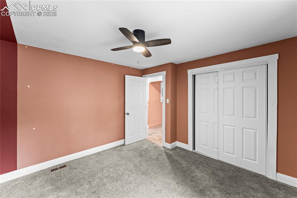 917 East Cimarron Street Colorado Springs, CO 80903 - Photo 14 of 26 Unfurnished bedroom featuring carpet, a ceiling fan, and a closet