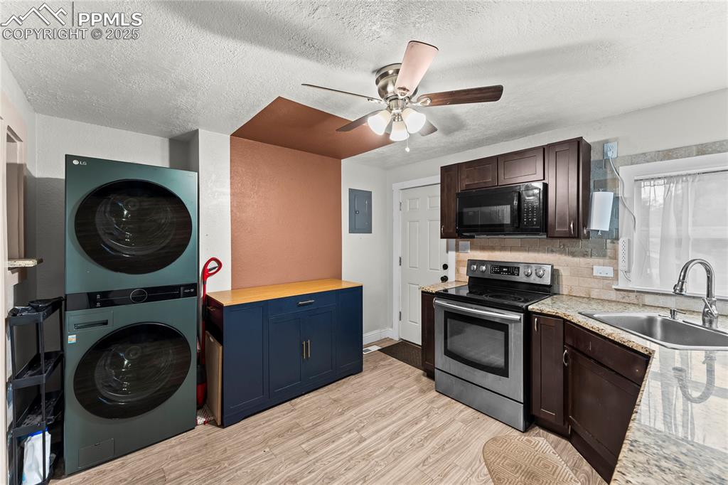 917 East Cimarron Street Colorado Springs, CO 80903 - Photo 9 of 26 Kitchen with stainless steel electric range, light wood-style flooring, black microwave, a textured ceiling, and butcher block counters