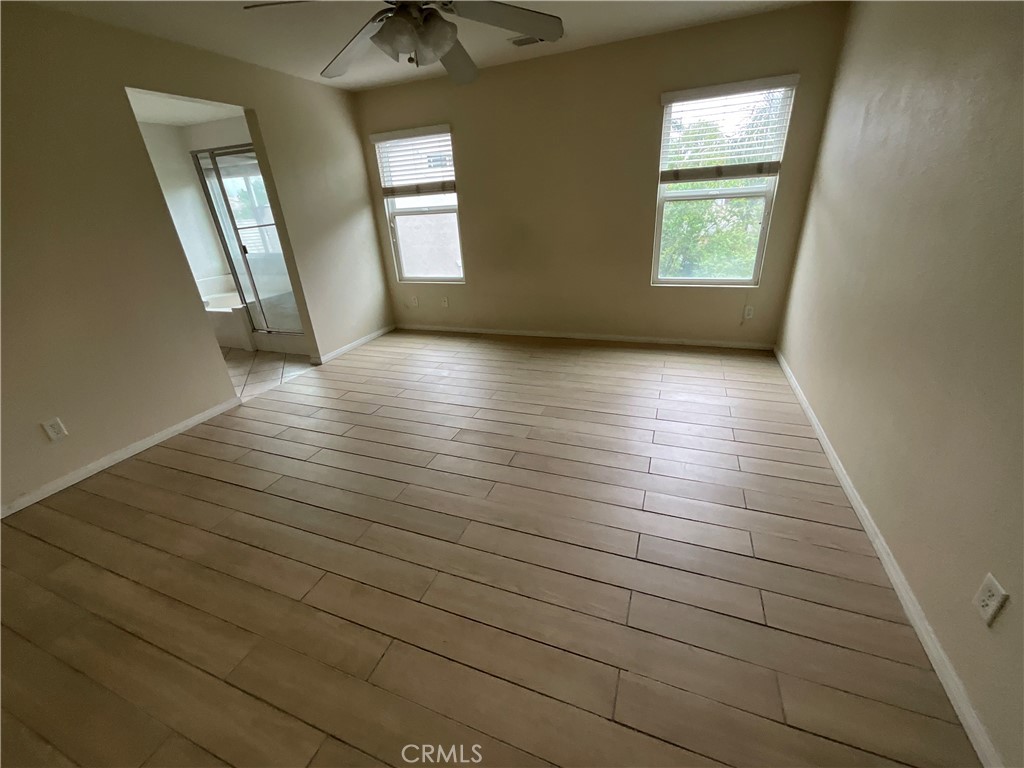 11875 Cedarbrook Place Rancho Cucamonga, CA 91730 - Photo 12 of 26 an empty room with wooden floor and windows
