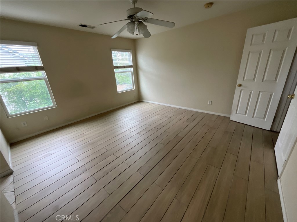11875 Cedarbrook Place Rancho Cucamonga, CA 91730 - Photo 13 of 26 an empty room with wooden floor staircase and windows