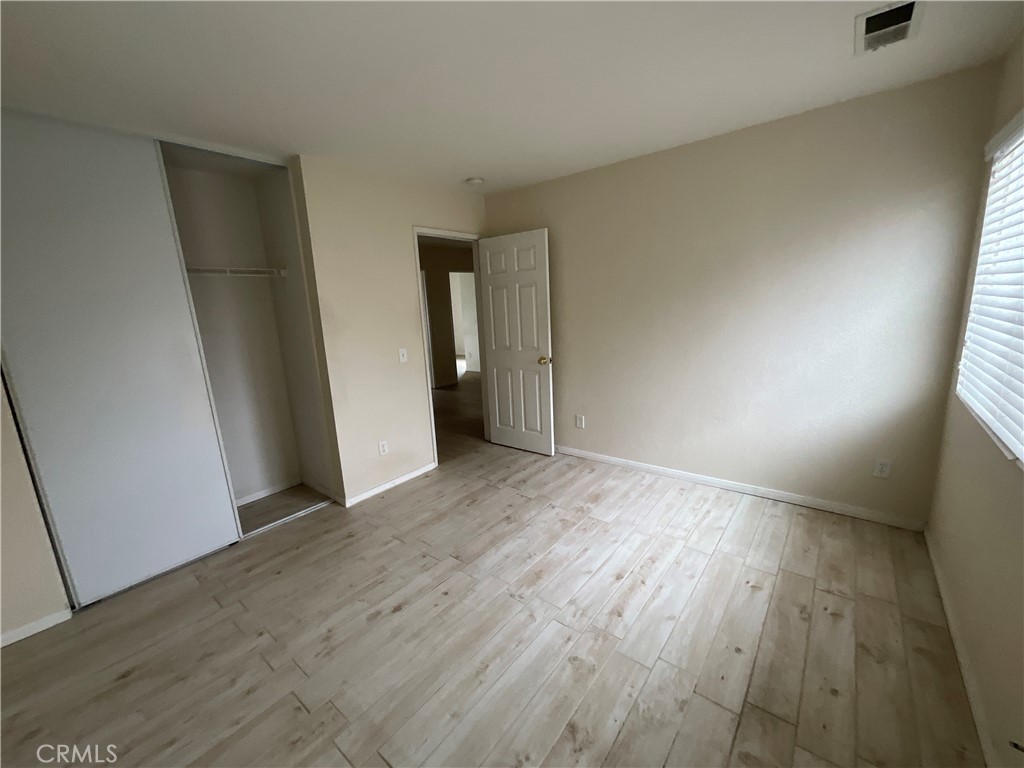 11875 Cedarbrook Place Rancho Cucamonga, CA 91730 - Photo 22 of 26 an empty room with wooden floor and entrance
