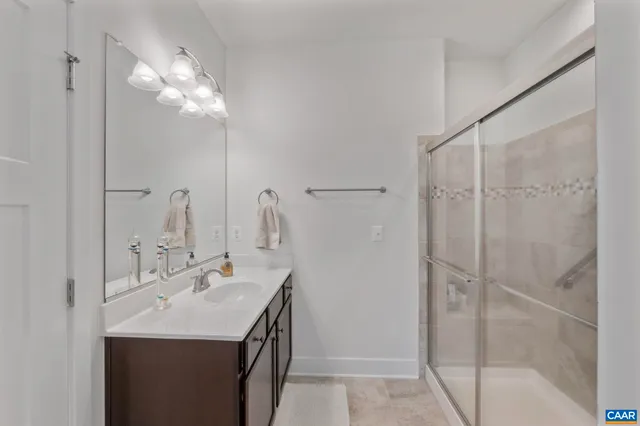a bathroom with a double vanity sink mirror and shower