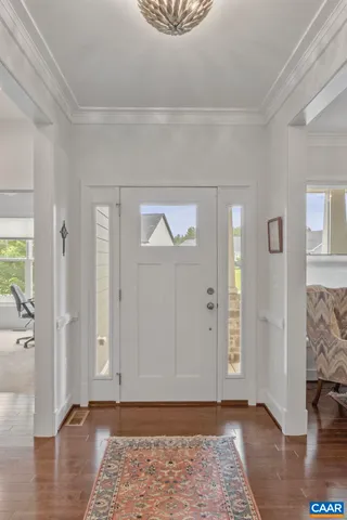 an empty room with wooden floor and a rug