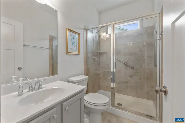 a bathroom with a shower sink vanity mirror and toilet