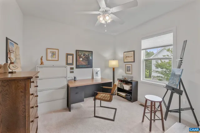 a view of a workspace with furniture and a window