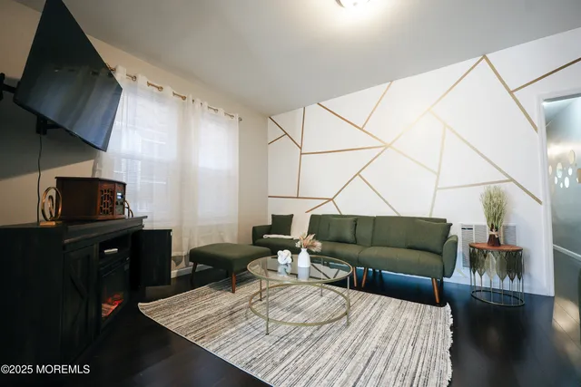 a living room with furniture a rug and a flat screen tv