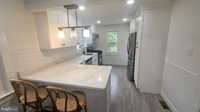 a kitchen with a table chairs refrigerator and microwave