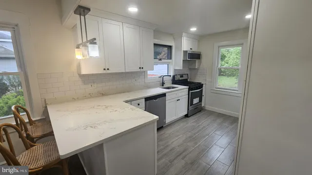 a kitchen with a sink cabinets and wooden floor