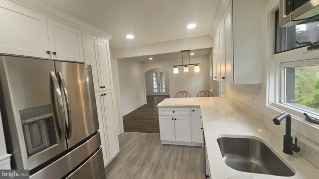 a kitchen with a refrigerator sink and cabinets