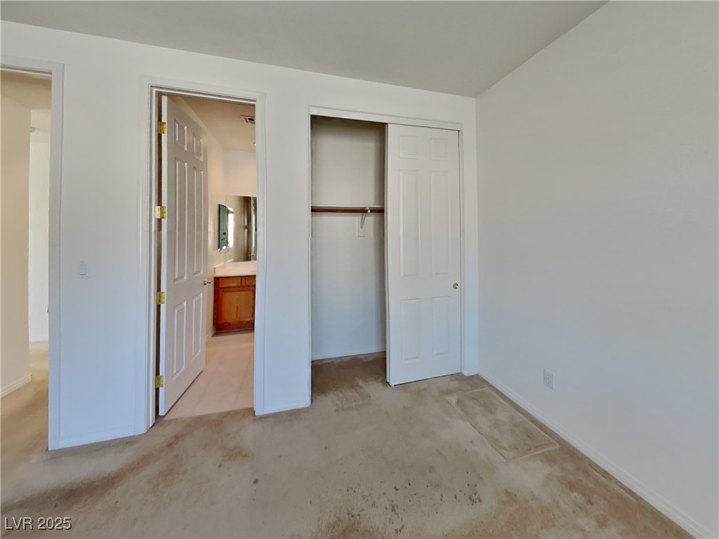 9456 Bluff Ledge Avenue Las Vegas, NV 89149 - Photo 16 of 35 Unfurnished bedroom with light colored carpet, a closet, and ensuite bath