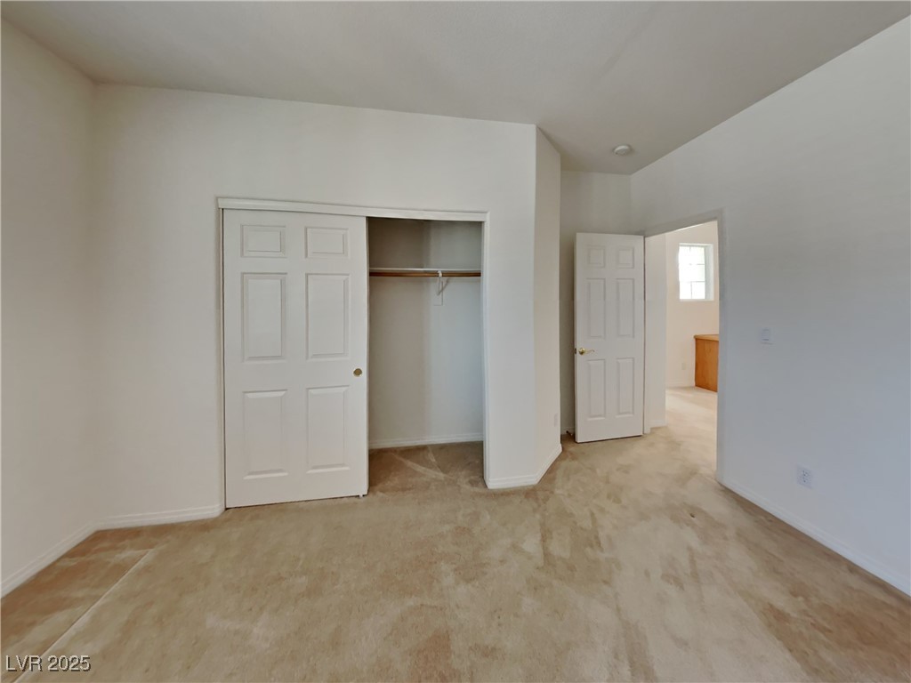 9456 Bluff Ledge Avenue Las Vegas, NV 89149 - Photo 2 of 35 Unfurnished bedroom with light colored carpet and a closet