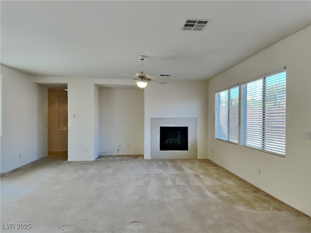 9456 Bluff Ledge Avenue Las Vegas, NV 89149 - Photo 26 of 35 Unfurnished living room with a fireplace, carpet, and ceiling fan