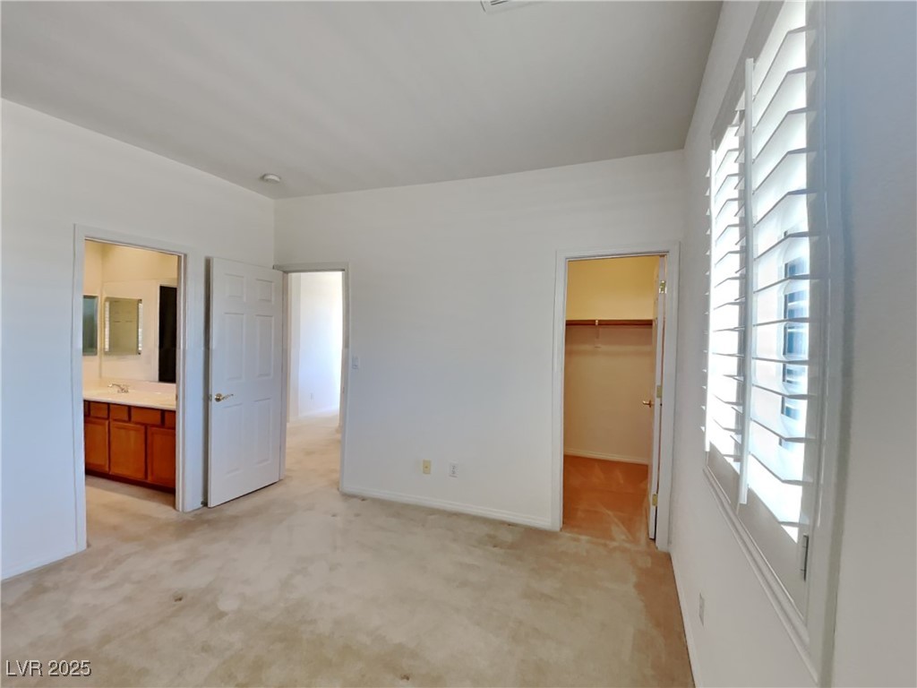 9456 Bluff Ledge Avenue Las Vegas, NV 89149 - Photo 6 of 35 Unfurnished bedroom featuring light colored carpet and a spacious closet