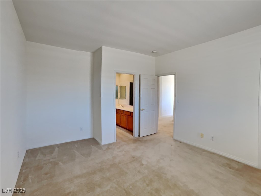9456 Bluff Ledge Avenue Las Vegas, NV 89149 - Photo 7 of 35 Unfurnished bedroom with light carpet and ensuite bathroom