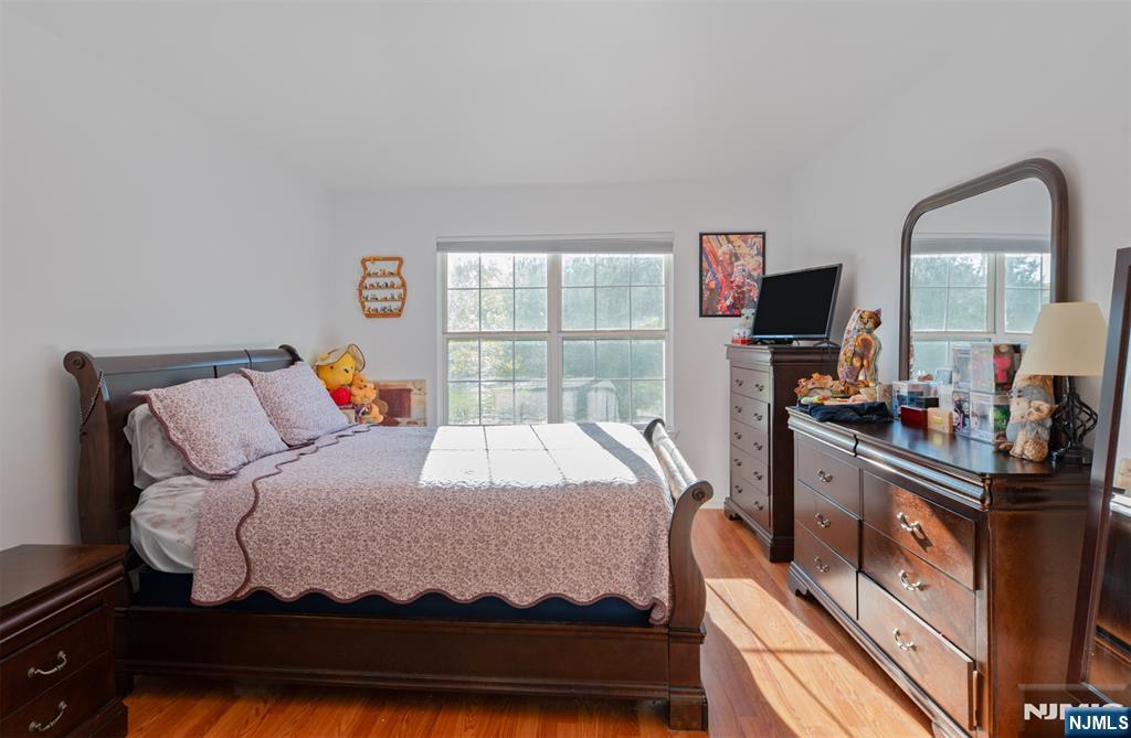 11 Parkside Court Wayne, NJ 07470 - Photo 14 of 22 a bedroom with a bed and a flat tv screen on the dresser
