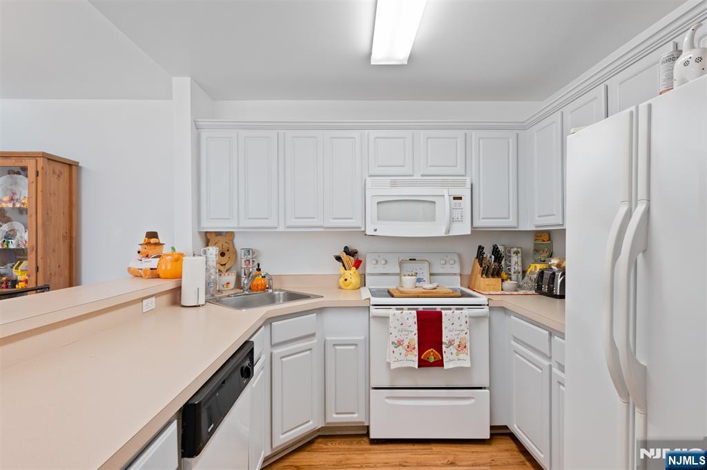 11 Parkside Court Wayne, NJ 07470 - Photo 10 of 22 a kitchen with stainless steel appliances a white refrigerator stove and white cabinets