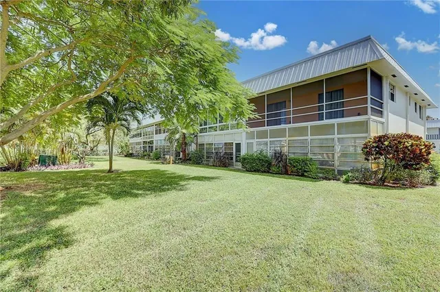 a view of a house with backyard and trees