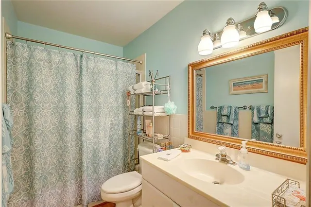 a bathroom with a sink vanity mirror and toilet