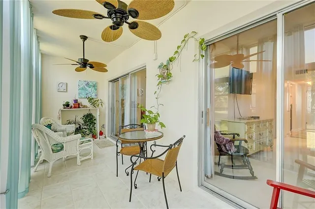 a dining room with furniture and a chandelier fan
