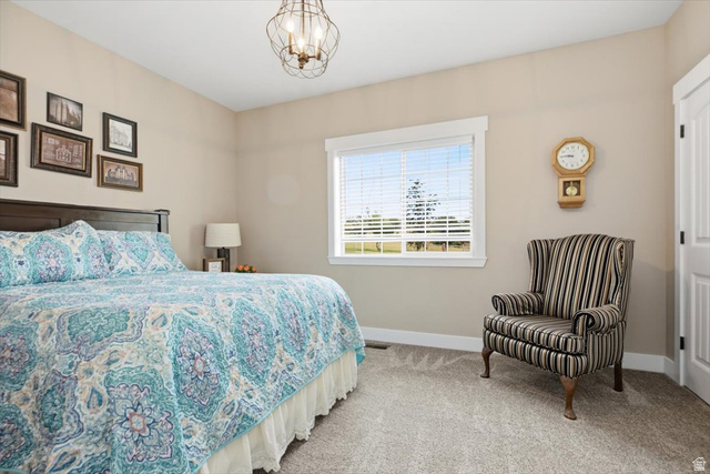 3123 East Riverdale Road Preston, ID 83263 - Photo 20 of 52 Bedroom featuring a large window, broad white trim, neutral wall color, and textured carpet flooring