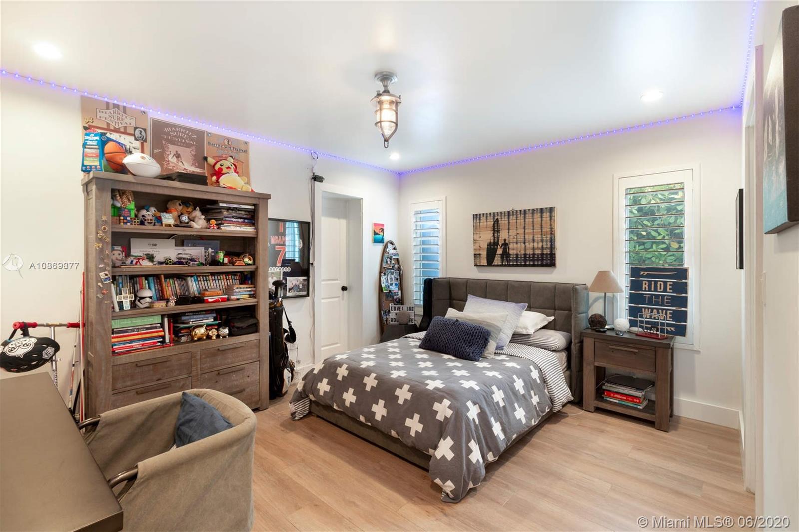 677 Ridgewood Road Key Biscayne, FL 33149 - Photo 18 of 38 a bedroom with a big bed and a book shelf