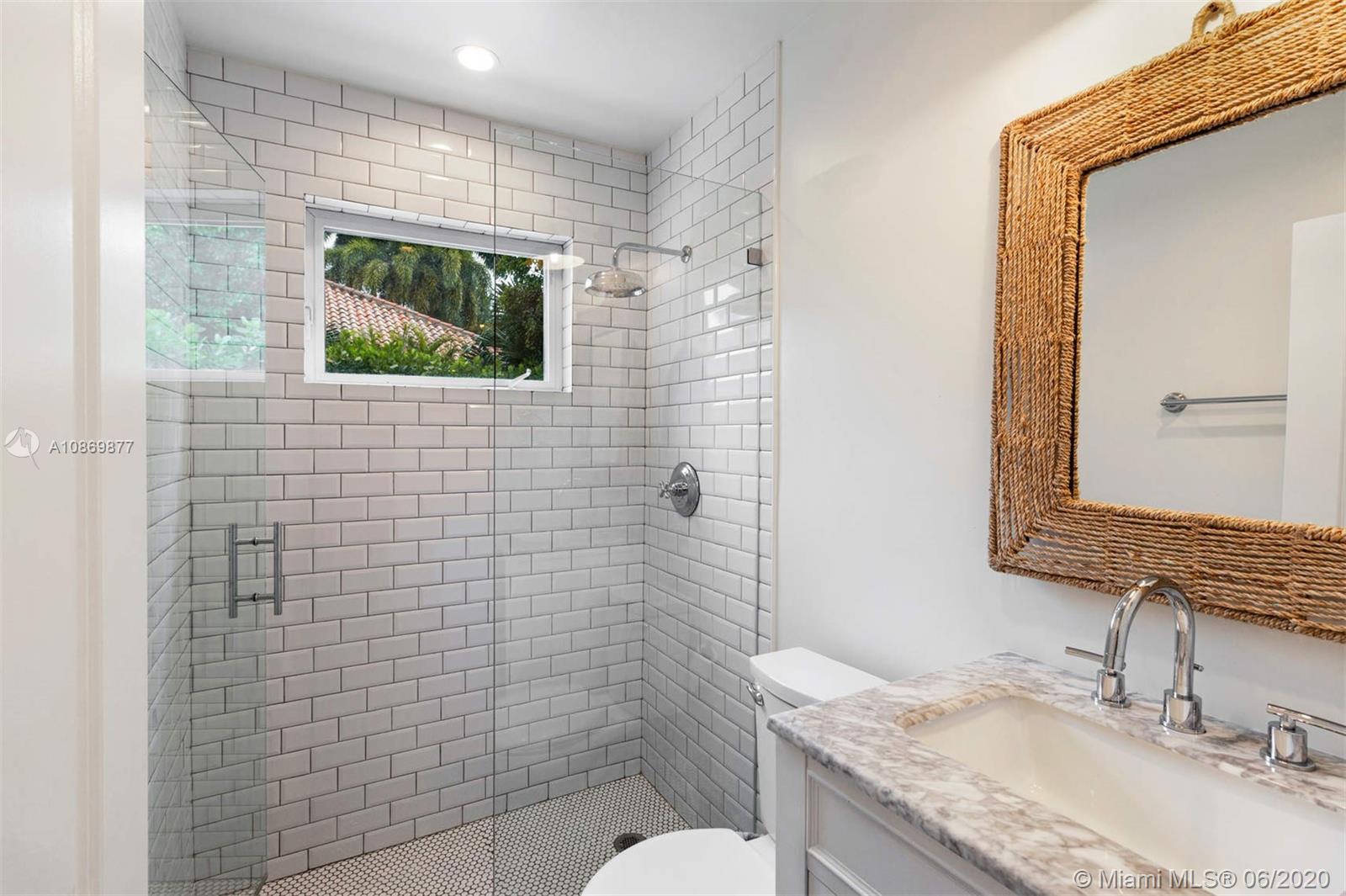 677 Ridgewood Road Key Biscayne, FL 33149 - Photo 19 of 38 a bathroom with a granite countertop toilet sink and mirror