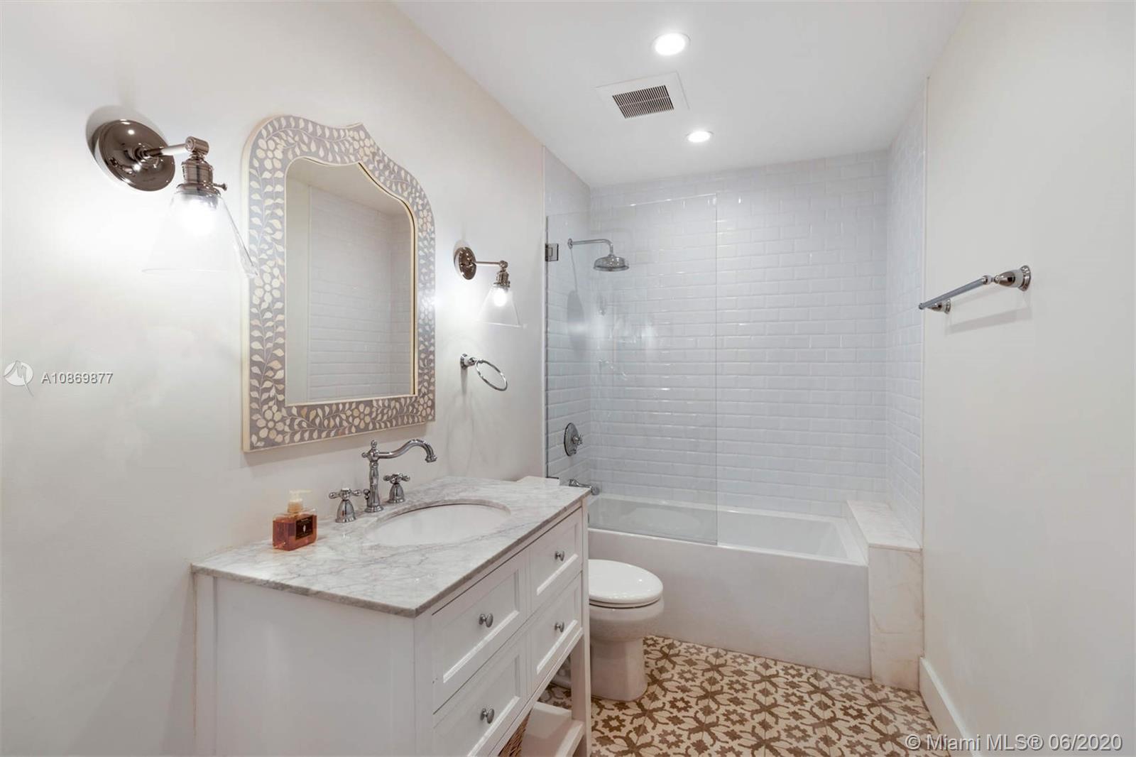 677 Ridgewood Road Key Biscayne, FL 33149 - Photo 21 of 38 a bathroom with a sink a toilet a mirror and shower