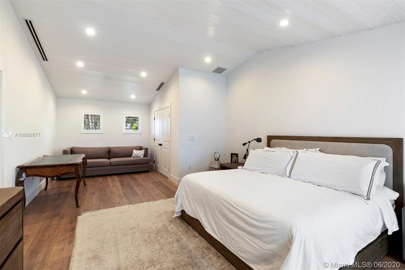 677 Ridgewood Road Key Biscayne, FL 33149 - Photo 26 of 38 a spacious bedroom with a bed and furniture