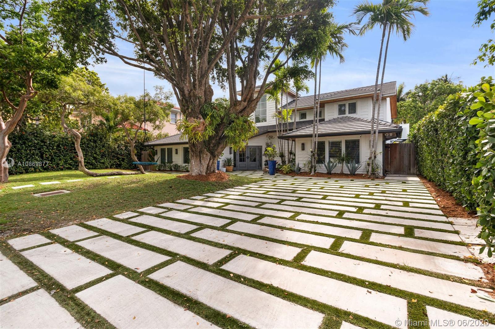 677 Ridgewood Road Key Biscayne, FL 33149 - Photo 30 of 38 a front view of a house with a garden and trees
