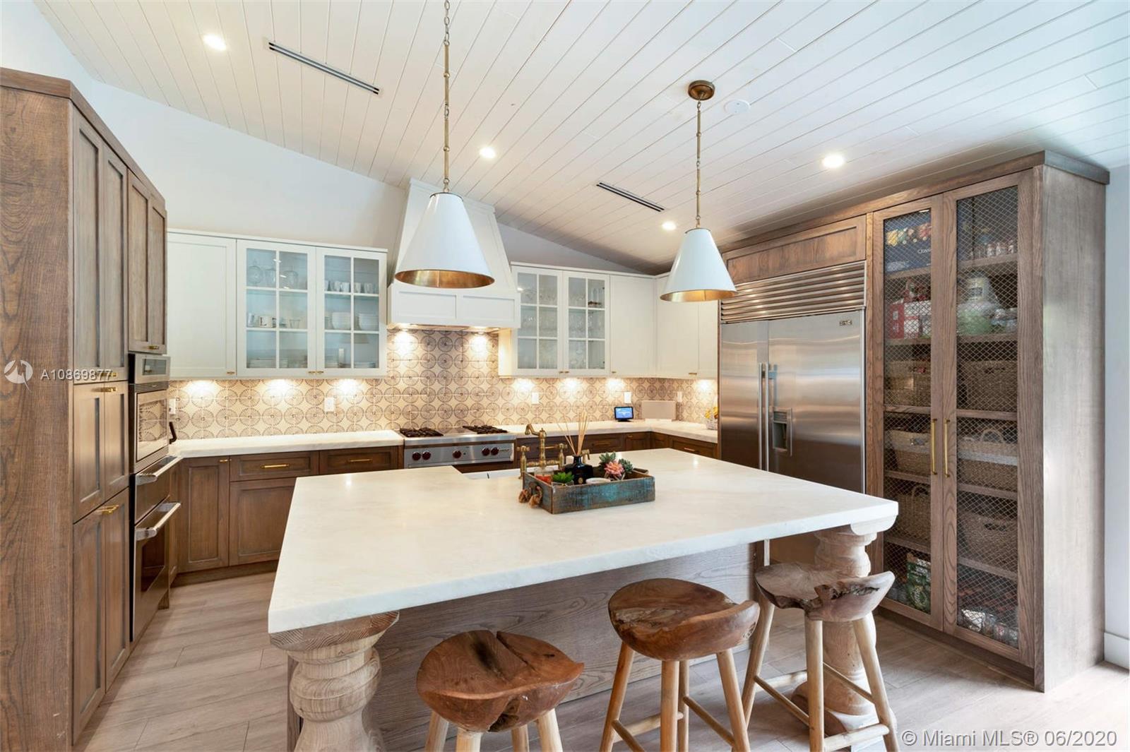 677 Ridgewood Road Key Biscayne, FL 33149 - Photo 7 of 38 a kitchen with stainless steel appliances a dining table chairs and wooden floor